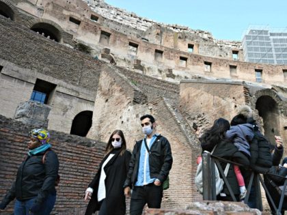 Tourists wearing respiratory masks visit the Coliseum in Rome on March 6, 2020. - Italy on March 5 reported 41 new deaths from the novel coronavirus, its highest single-day total to date, bringing the number of fatalities in Europe's most affected country to 148. All of Italy's 22 regions have …