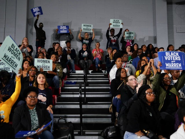 Attendees cheer and hold signs as Sen. Elizabeth Warren (D-MA), speaks at a campaign event
