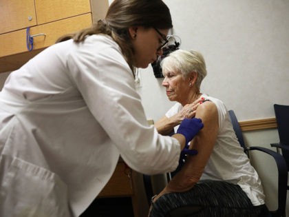 MIAMI, FL - OCTOBER 04: Luanne Boiko receives an influenza vaccination from nurse practiti