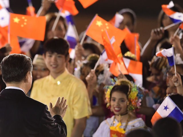 China's President Xi Jinping (L) waves at children upon landing at the airport in Panama C