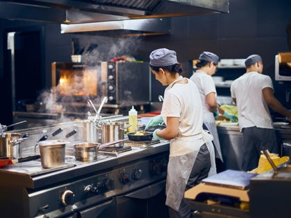 the team of cooks backs in the work in the modern kitchen, the workflow of the restaurant