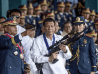 This file photo taken on April 19, 2018 shows Philippine President Rodrigo Duterte holding a Galil sniper rifle with outgoing Philippine National Police (PNP) chief Ronald dela Rosa (L) during the change of command ceremony at Camp Crame in Manila. - Philippine President Rodrigo Duterte fired Vice President and arch-critic …