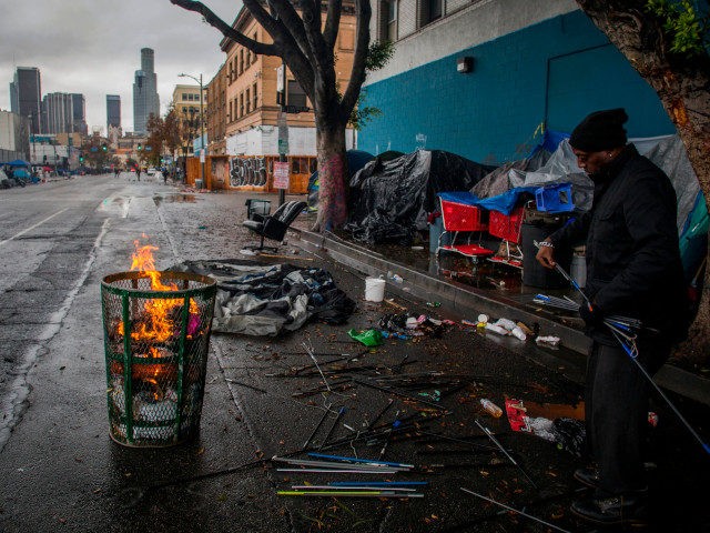 A homeless man makes a fire from trash to keep warm in Skidrow on Thanksgiving day in Los