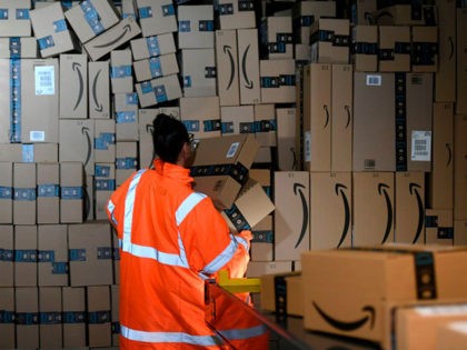 An employee places packed goods tons container at the distribution center of US online retail giant Amazon in Moenchengladbach, on December 17, 2019. (Photo by INA FASSBENDER / AFP) (Photo by INA FASSBENDER/AFP via Getty Images)