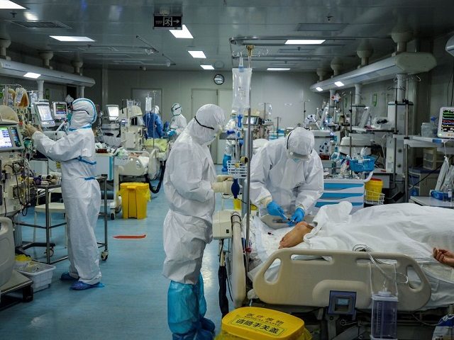 This photo taken on February 24, 2020 shows medical staff treating patients infected by the COVID-19 coronavirus at a hospital in Wuhan in China's central Hubei province. - The new coronavirus has peaked in China but could still grow into a pandemic, the World Health Organization warned, as infections mushroom …