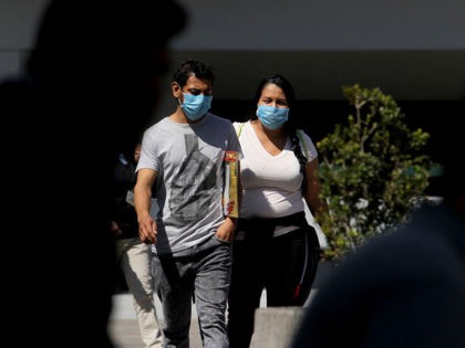 A man and a woman walking in the streets of Guadalajara, Mexico, wear protective face masks on February 28, 2020 as the new coronoavirus, COVID-19, spreads worldwide. - Mexico's Health Ministry confirmed the country's first cases of coronavirus on Friday, saying two men who recently returned from Italy tested positive …