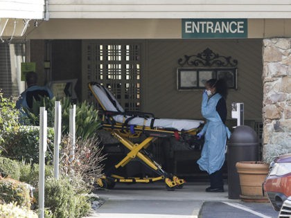 A stretcher is moved from an AMR ambulance to the Life Care Center of Kirkland where one a