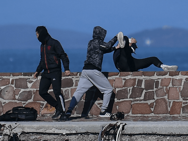 TOPSHOT - A journalist (R) is attacked by residents who are trying to prevent migrants from disembarking on the Greek island of Lesbos, on March 1, 2020. - The United Nation called on March 1 for calm and urged states to refrain from "excessive" force, as thousands of migrants have …