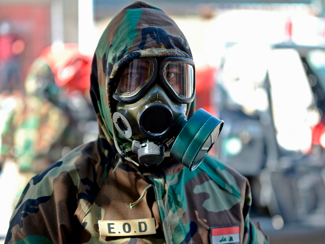 A member of the Iraqi civil defence prepares to disinfect a neighbourhood where a recent c