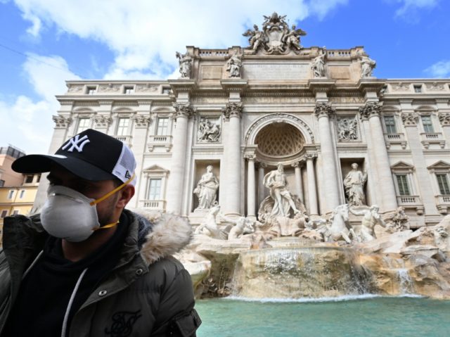 A tourist wear a protective mask in front of the Trevi Fountain downtown Rome, on March 3,
