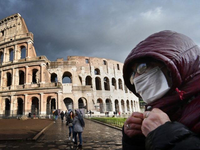 TOPSHOT - A man wearing a protective mask passes by the Coliseum in Rome on March 7, 2020 amid fear of Covid-19 epidemic. - Italy on March 6, 2020 reported 49 more deaths from the new coronavirus, the highest single-day toll to date, bringing the total number of fatalities over …
