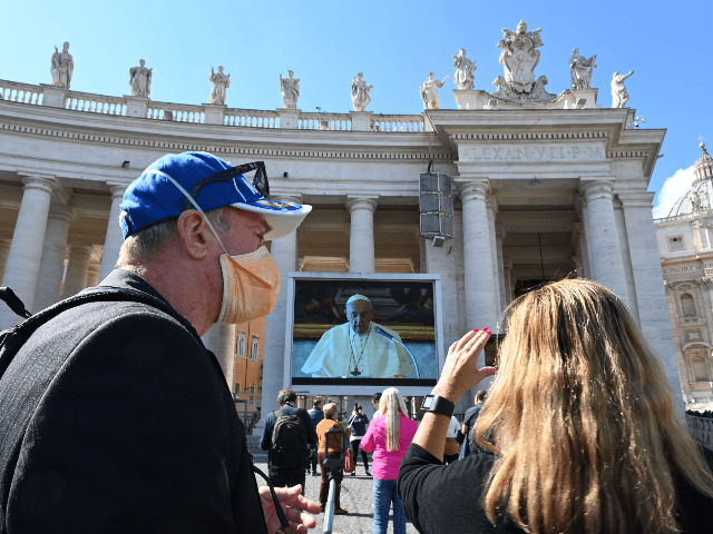 A couple takes smartphone pictures of a screen live-broadcasting Pope Francis' Sunday Ange
