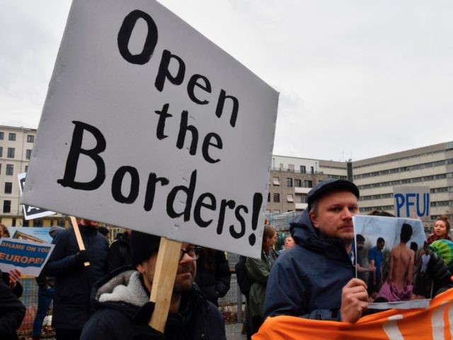Demonstrators hold up a poster reading "Open the Borders" as they protest against Europe's migration policy and the handling of refugees at the Greek border as protesters gather opposite the venue of a German-Hellenic Economic Forum in Berlin on March 9, 2020. (Photo by John MACDOUGALL / AFP) (Photo by …