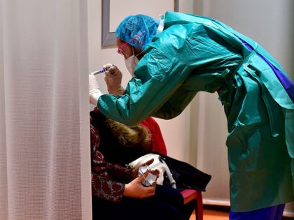 A doctor examines a patient at the hospital screening unit of the CHU Pellegrin in Bordeaux, southwestern France on March 9, 2020. - The CHU Pellegrin in Bordeaux has opened a screening unit for the novel coronavirus where patients are examined in a box by a team made up of …
