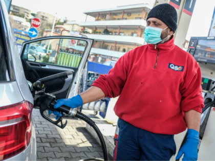 A petrol station employee wearing a respiratory mask as part of precautionary measures aga