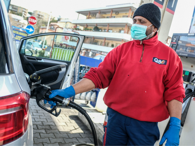 A petrol station employee wearing a respiratory mask as part of precautionary measures aga