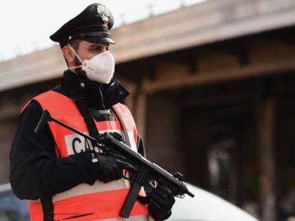 An armed Italian Carabinieri police officer, wearing a respiratory mask as part of precaut