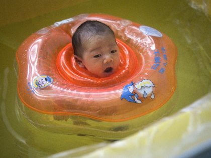 A baby swims in a bath at private maternity hospital on March 12, 2020 in Wuhan, Hubei, China. Due to the shortage of medical resources in Wuhan, many pregnant women choose to give birth in private hospitals.Flights, trains and public transport including buses, subway and ferry services have been closed …