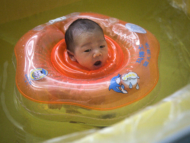 A baby swims in a bath at private maternity hospital on March 12, 2020 in Wuhan, Hubei, Ch