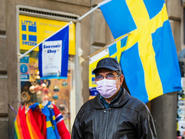 A toursit wears a protective face mask as he visits the old town in Stockholm on March 13,