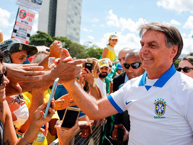 Brazilian President Jair Bolsonaro greets supporters in front of the Planalto Palace, afte