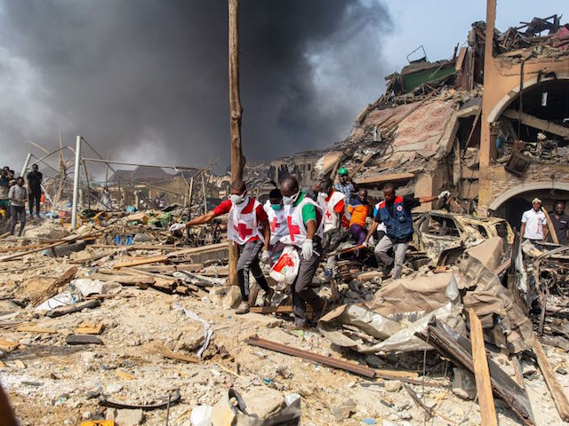 Members of the Red Cross carry a dead body after a gas explosion destroyed buildings and killed at least 15 people, in Nigeria's commercial capital Lagos on March 15, 2020 - A gas explosion in Nigeria's commercial capital Lagos killed at least 15 people, injured many more and destroyed around 50 buildings on March 15, 2020. (Photo by Benson IBEABUCHI / AFP) (Photo by BENSON IBEABUCHI/AFP via Getty Images)