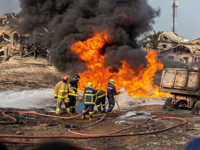 Firefighters try to extinguish a fire from the scene of a gas explosion near destroyed buildings in Lagos on March 15, 2020. - A gas explosion in Nigeria's commercial capital Lagos killed at least 15 people, injured many more and destroyed around 50 buildings on March 15, 2020. (Photo by Benson IBEABUCHI / AFP) (Photo by BENSON IBEABUCHI/AFP via Getty Images)