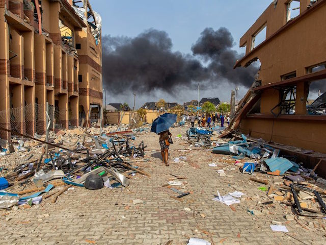 TOPSHOT - This picture taken on March 15, 2020, shows scattered debris while a fire is still burning at the scene of a gas explosion in Lagos. - A gas explosion in Nigeria's commercial capital Lagos killed at least 15 people, injured many more and destroyed around 50 buildings on March 15, 2020. (Photo by Benson IBEABUCHI / AFP) (Photo by BENSON IBEABUCHI/AFP via Getty Images)
