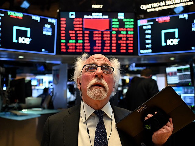 Traders work during the opening bell at the New York Stock Exchange (NYSE) on March 16, 2020 at Wall Street in New York City. - Trading on Wall Street was halted immediately after the opening bell Monday, as stocks posted steep losses following emergency moves by the Federal Reserve to …