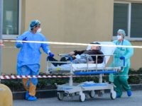 Medical workers wearing a face make and protection gear bring a patient on a stretcher inside the new coronavirus intensive care unit of the Brescia Poliambulanza hospital, Lombardy, on March 17, 2020. (Photo by Piero CRUCIATTI / AFP) (Photo by PIERO CRUCIATTI/AFP via Getty Images)
