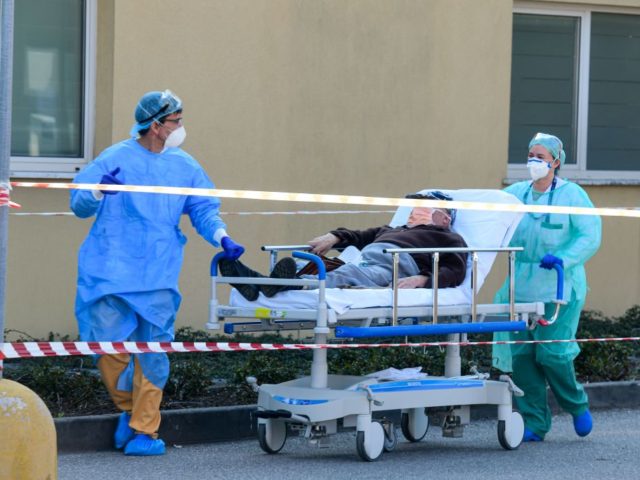 Medical workers wearing a face make and protection gear bring a patient on a stretcher inside the new coronavirus intensive care unit of the Brescia Poliambulanza hospital, Lombardy, on March 17, 2020. (Photo by Piero CRUCIATTI / AFP) (Photo by PIERO CRUCIATTI/AFP via Getty Images)