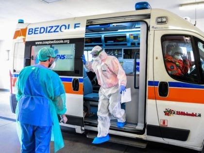 A medical worker wearing a face mask brings a patient in an ambulance arriving at the new coronavirus intensive care unit of the Brescia Poliambulanza hospital, Lombardy, on March 17, 2020. (Photo by Piero CRUCIATTI / AFP) (Photo by PIERO CRUCIATTI/AFP via Getty Images)