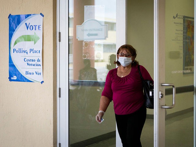 A woman wearing mask and protective gloves leaves after cast her vote during the Florida D