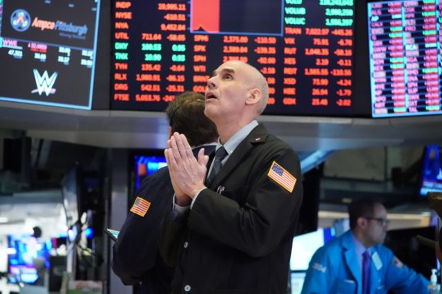 TOPSHOT - Traders work on the floor at the opening bell of the Dow Industrial Average at t