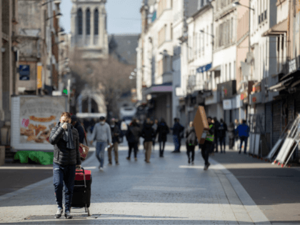 People walk in a shopping street of Saint-Denis, near Paris on March 18, 2020, after a strict lockdown came into effect in France to stop the spread of the COVID-19, caused by the novel coronavirus. - A strict lockdown requiring most people in France to remain at home came into …