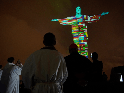 The illuminated statue of Christ the Redeemer as Archbishop of the city of Rio de Janeiro, Dom Orani Tempesta, performs a mass in honor of the victims of COVID-19 around the world in Rio de Janeiro, on March 18, 2020 in Rio de Janeiro, Brazil. (Photo by Wagner Meier/Getty Images)