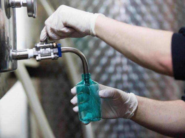 TOPSHOT - Distiller Phil Miller pours hand sanitizers at Spirit of York distillery in Toro