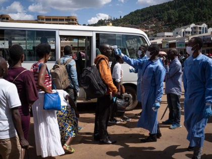 A staff of the Rwanda Biomedical Center (RBC) screens passengers at a bus station after th