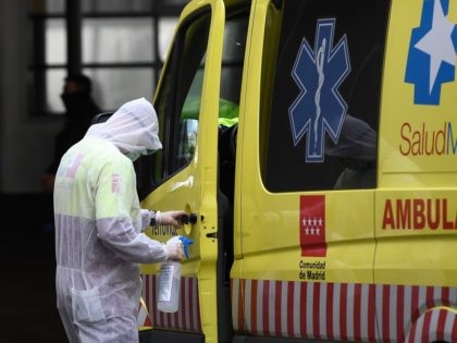 A paramedic disinfects the door handle of an ambulance outside La Paz hospital in Madrid on March 23, 2020 amid a national lockdown to fight the spread of the COVID-19 coronavirus. - The coronavirus death toll in Spain surged to 2,182 after 462 people died within 24 hours, the health …
