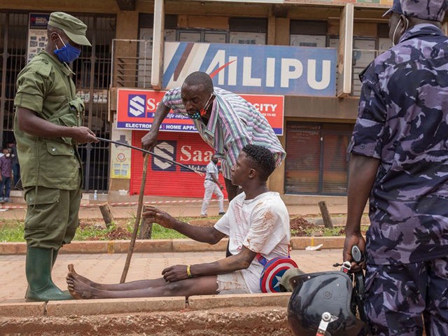A police officer arrests a man on a street in Kampala, Uganda, on March 26, 2020, after Ugandan President Yoweri Museveni directed the public to stay home for 32 days starting March 22, 2020 to curb the spread of the COVID-19 coronavirus. - Ugandan authorities have identified 14 confirmed cases …