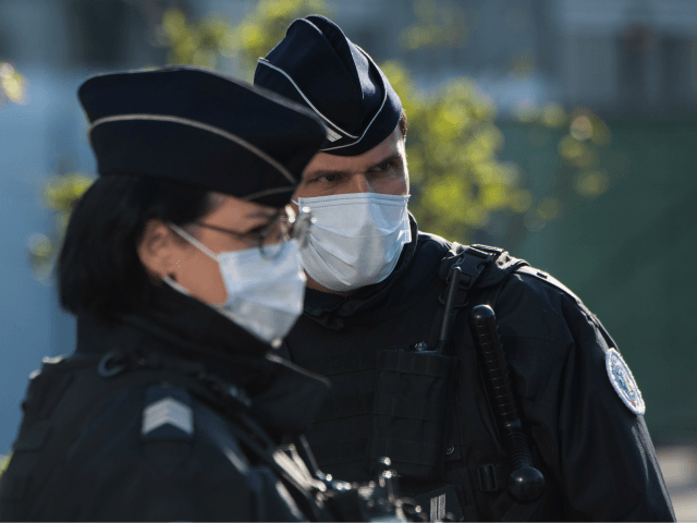 Police officers wearing a face mask stand guard in front of the Nantes railway station, on March 26, 2020 in Nantes, following the arrival of a medicalized TGV high-speed train carrying patients infected with the covid-19 from eastern France, where hospitals are overwhelmed. (Photo by Loic VENANCE / AFP) (Photo …