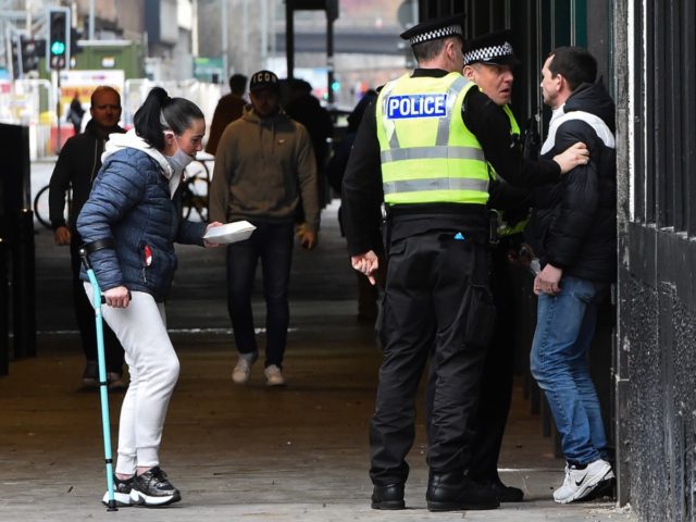 Police officers break up a group of people who had gathered in Glasgow city centre on March 27, 2020. - Britain is under lockdown, its population joining around 1.7 billion people around the globe ordered to stay indoors to curb the "accelerating" spread of the coronavirus. (Photo by ANDY BUCHANAN …