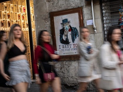 BARCELONA, SPAIN - MARCH 13: People walk past a poster of the artist TVBoy which it reads