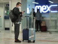 MEXICO CITY, MEXICO - MARCH 13: A passenger wearing a protective mask checks a phone after arriving at Mexico City airport on March 13, 2020 in Mexico City, Mexico. Mexican peso, crude oil price and Mexican stock market have been plunging considerably after WHO declared COVID-19 a pandemic on Wednesday …