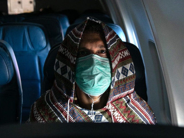 NEW YORK, NY - MARCH 15: Adam Carver, 38, wears a mask to protect against coronavirus while on a nearly empty Delta flight from Seattle-Tacoma International Airport o JFK on March 15, 2020 near New York City. Carver, a Brooklyn-based tech entrepreneur, was returning from an extended trip to Asia …
