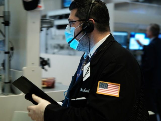 NEW YORK, NEW YORK - MARCH 20: Traders, some in medical masks, work on the floor of the New York Stock Exchange (NYSE) on March 20, 2020 in New York City. Trading on the floor will temporarily become fully electronic starting on Monday to protect employees from spreading the coronavirus. …