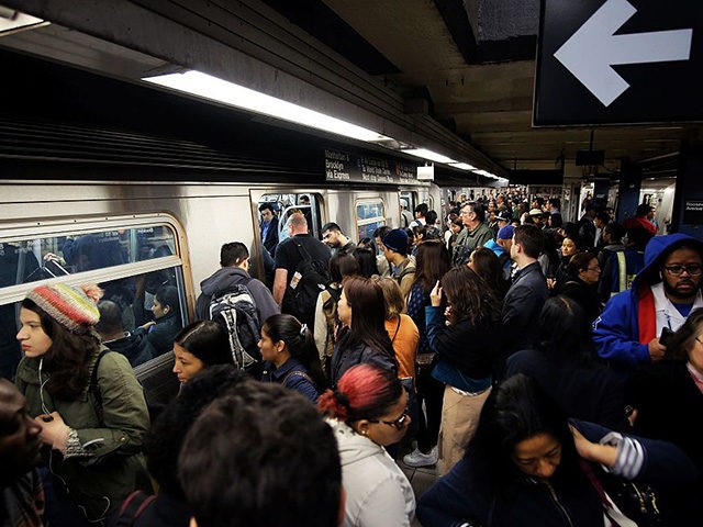 Morning commuters board a train in a crowded subway station in New York on May 11, 2016. /