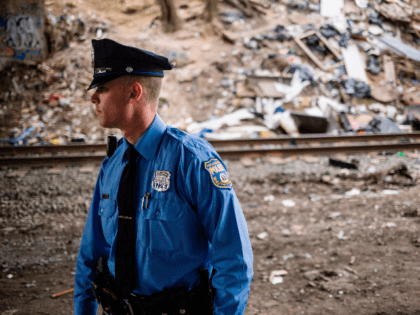 A Philadelphia Police officer patrols under a bridge near a heroin encampment in the Kensi
