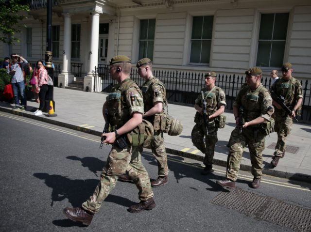 TOPSHOT - British Army soldiers are led by a police officer into Buckingham Palace in cent
