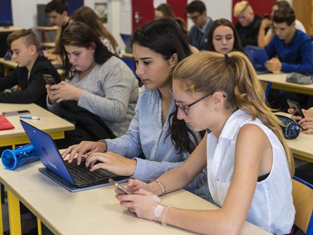 In this photograph taken on September 26, 2017, high school students use smartphones and tablet computers at the vocational school in Bischwiller, eastern France.